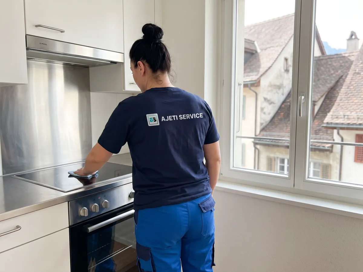 Umzugsreinigung Chur: Mitarbeiterin reinigt Kochfeld und Backofen einer Altstadtwohnung